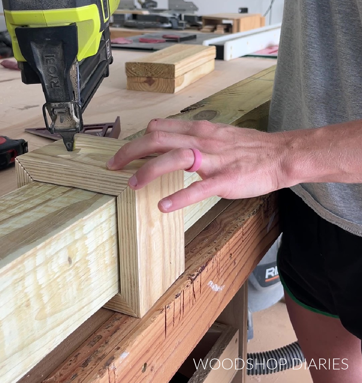 Close up of brad nailing trim around bottom of 4x4 lamp post