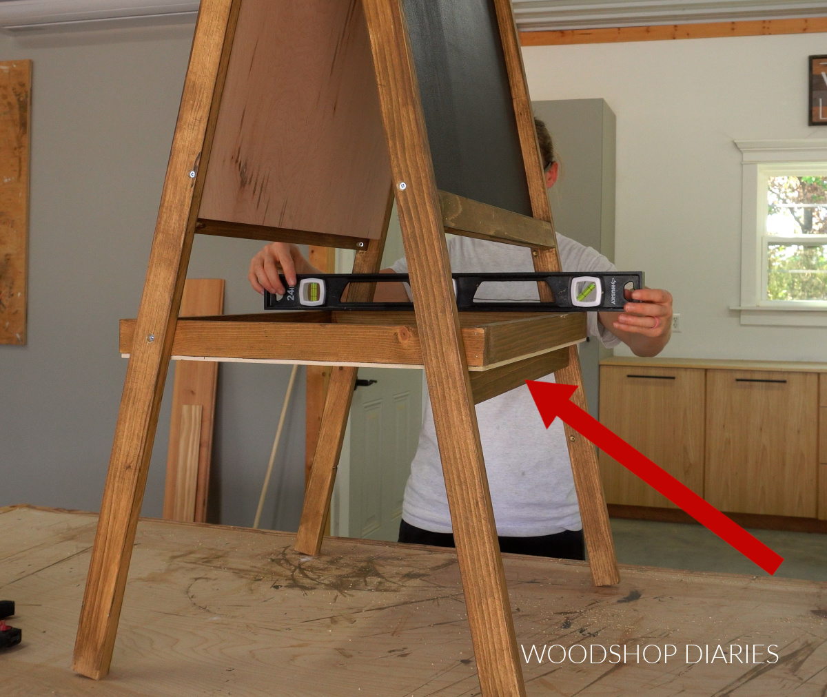 Shara Woodshop Diaries using a level to position tray support piece into easel frame