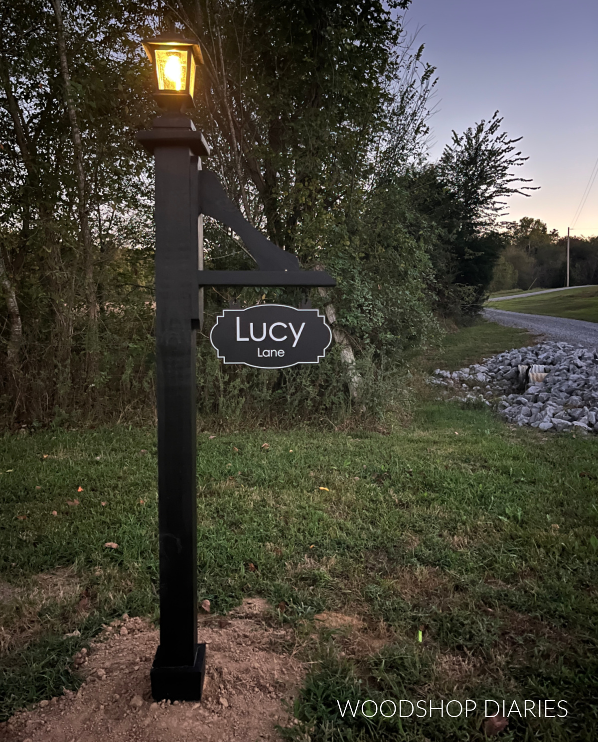 Decorative DIY wooden lamp post stained black at dusk with solar lantern on