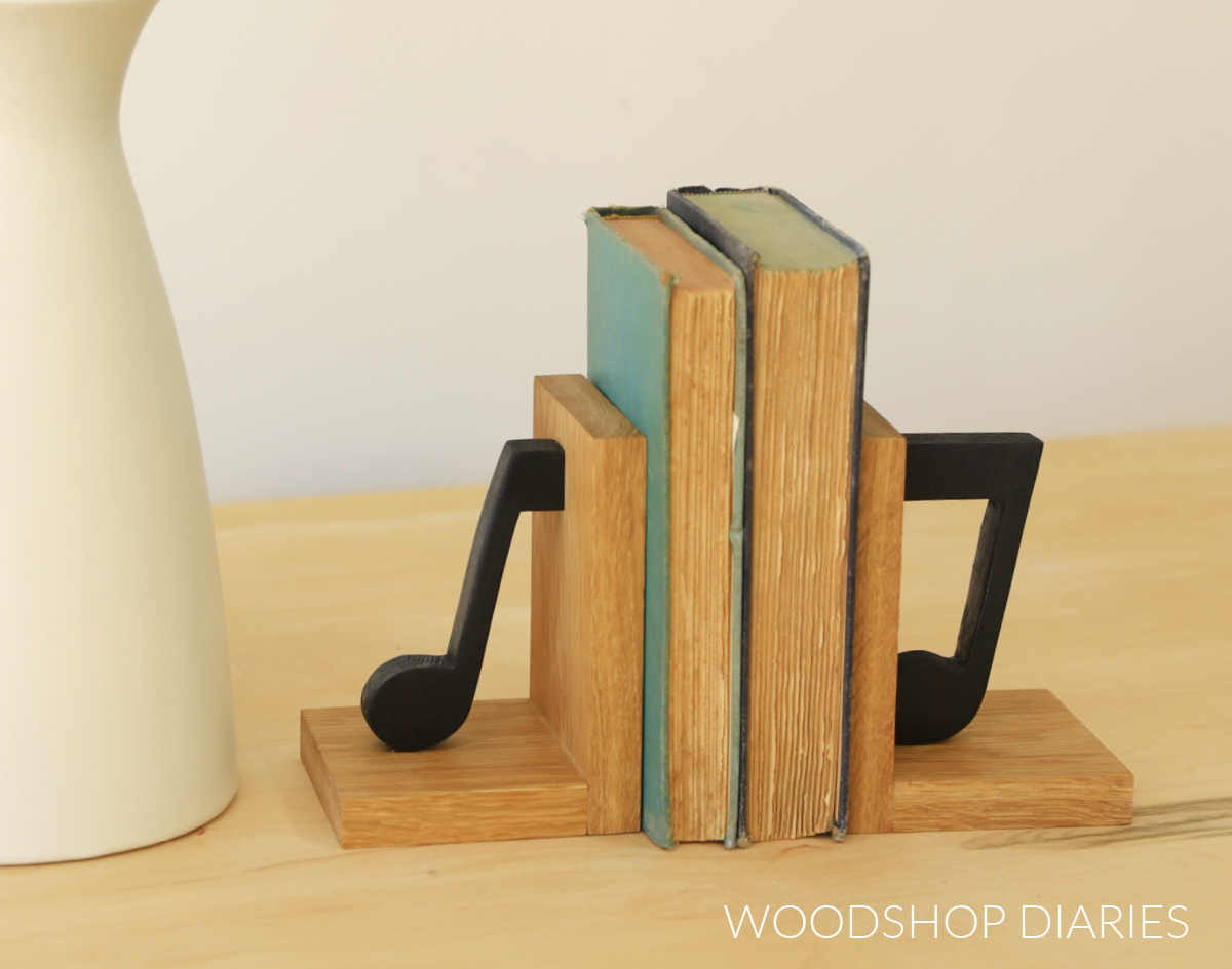 Finished personalized wooden bookends with music notes next to vase