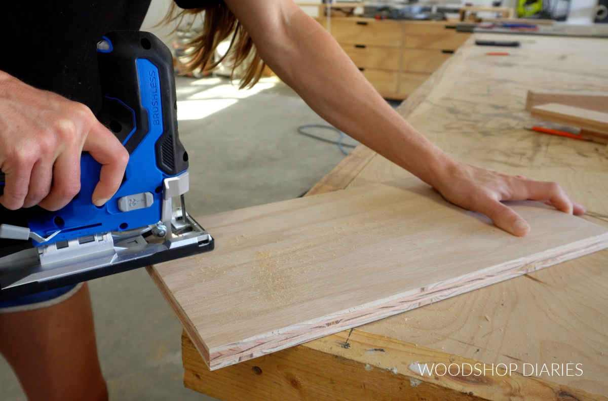 Close up of Shara Woodshop Diaries using jig saw to notch back corner of drawer divider