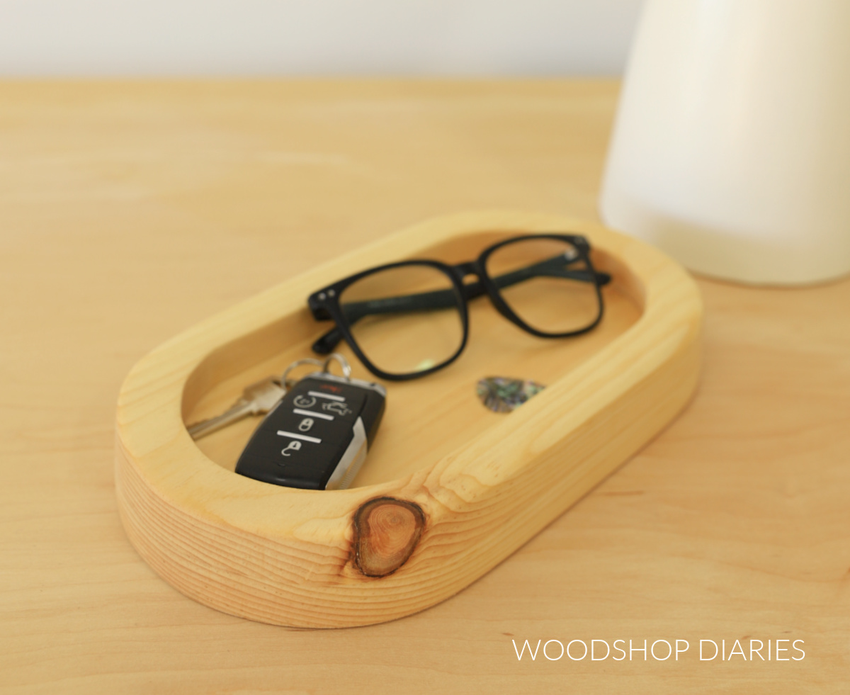 Oval shaped DIY wooden catch all tray made from pine with glasses, keys, and guitar pick inside