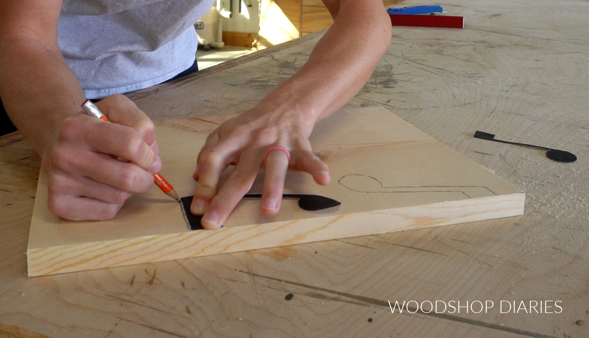 Shara Woodshop Diaries tracing music note shapes on scrap board with pencil