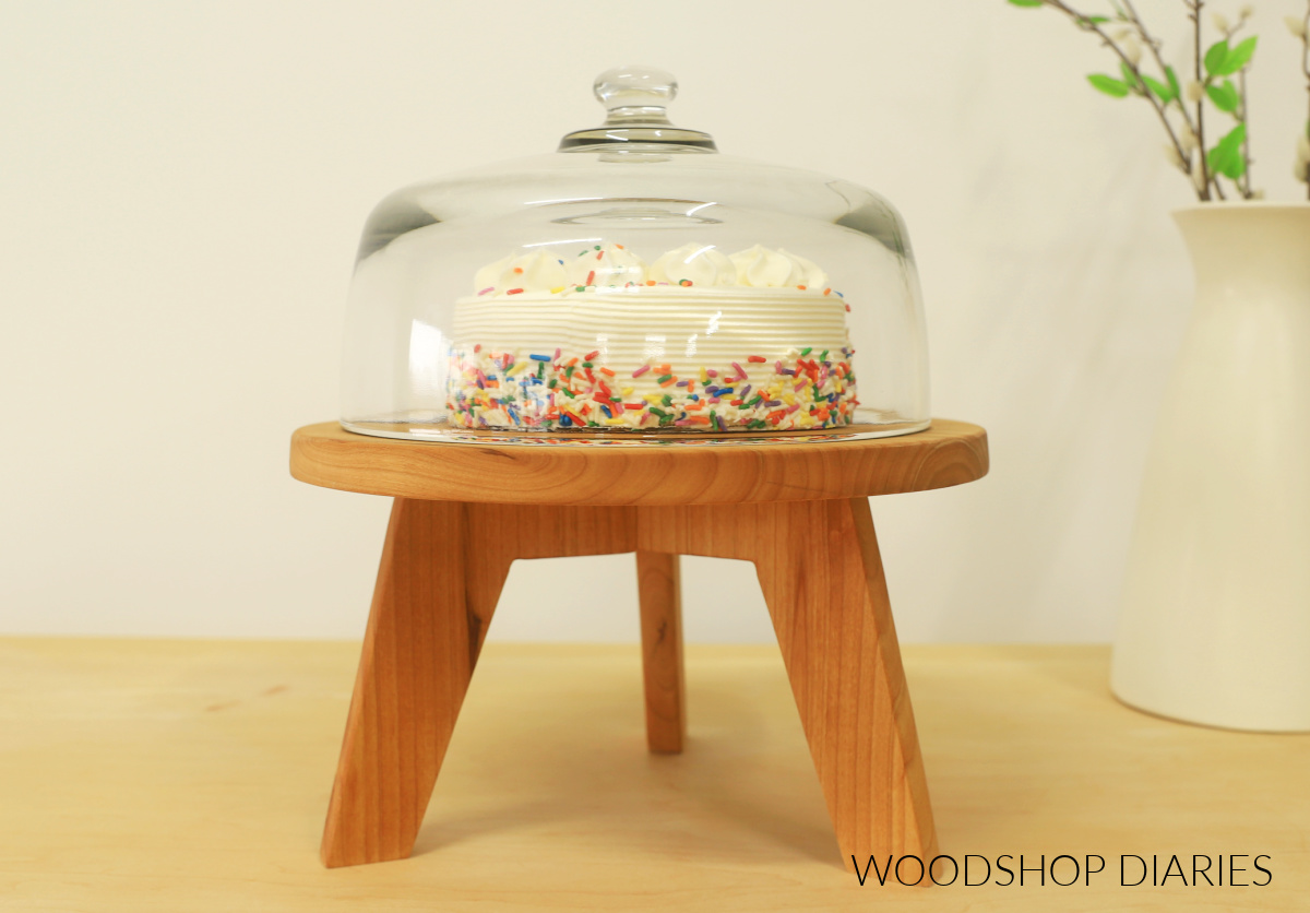 DIY wooden cake stand with glass dome. Cake stand top is round with mid century modern legs