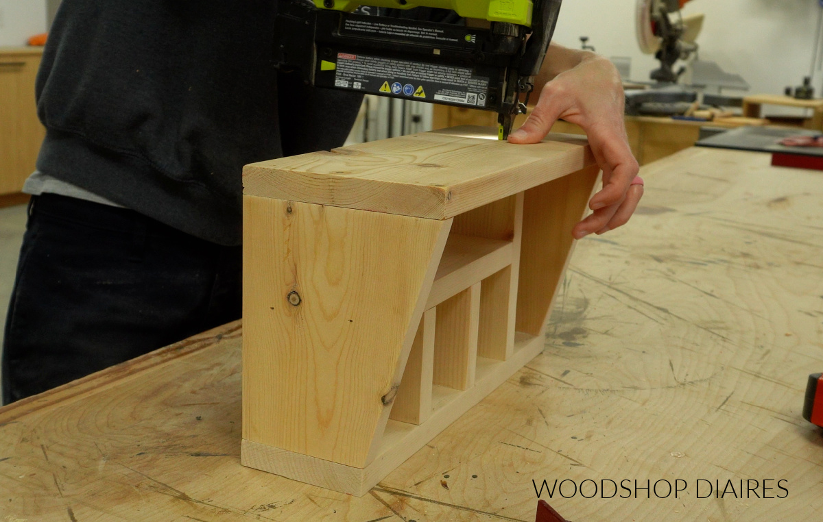 Shara Woodshop Diaries nailing back piece onto utensil holder on workbench