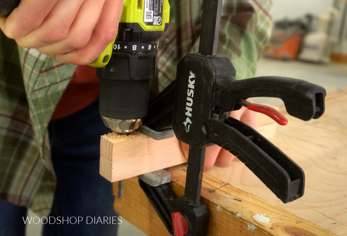 Close up of Shara Woodshop Diaries drilling hole in ends of trivet boards to install leather cord