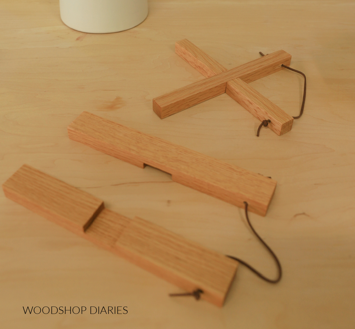DIY wooden cross trivets--one interlocked together and one set apart. Both tied together with leather cord
