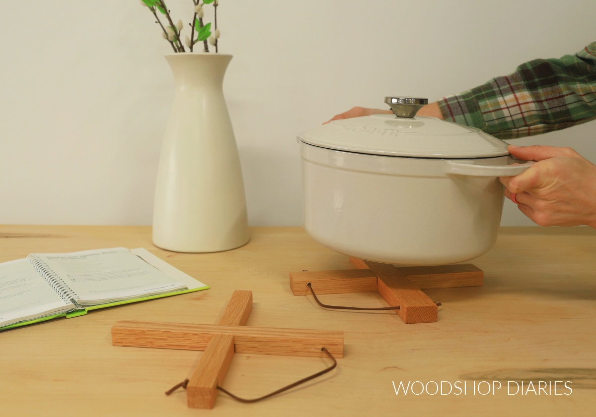 Shara Woodshop Diaries placing dutch oven pot on wooden cross trivet