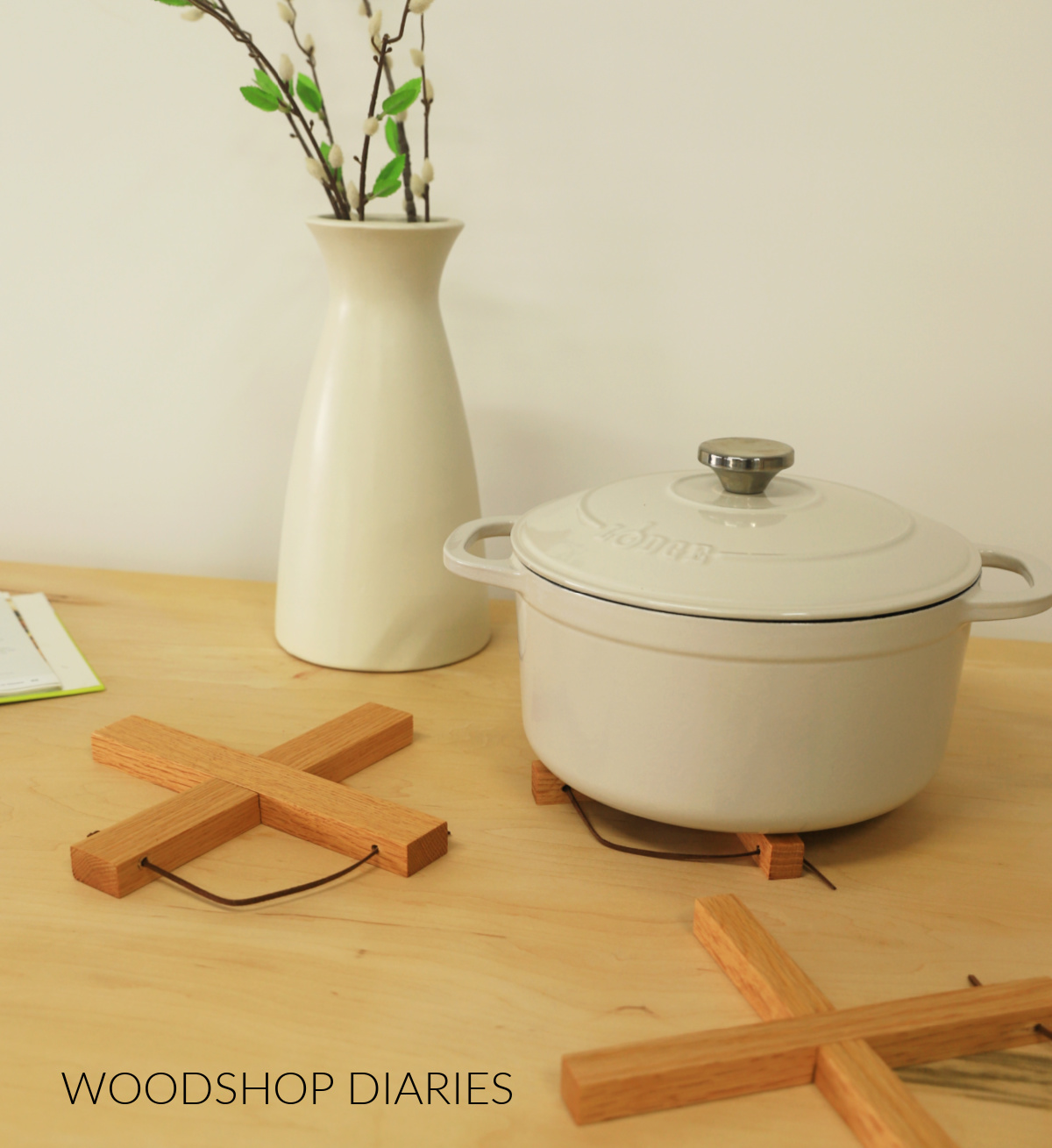 Three wooden cross trivets on tabletop. Dutch Oven post resting on one of them