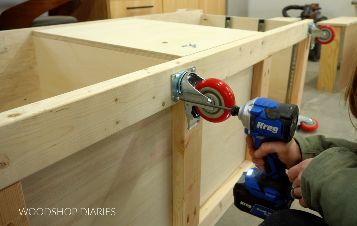Close up of installing caster wheels onto bottom of mobile miter saw stand using screws