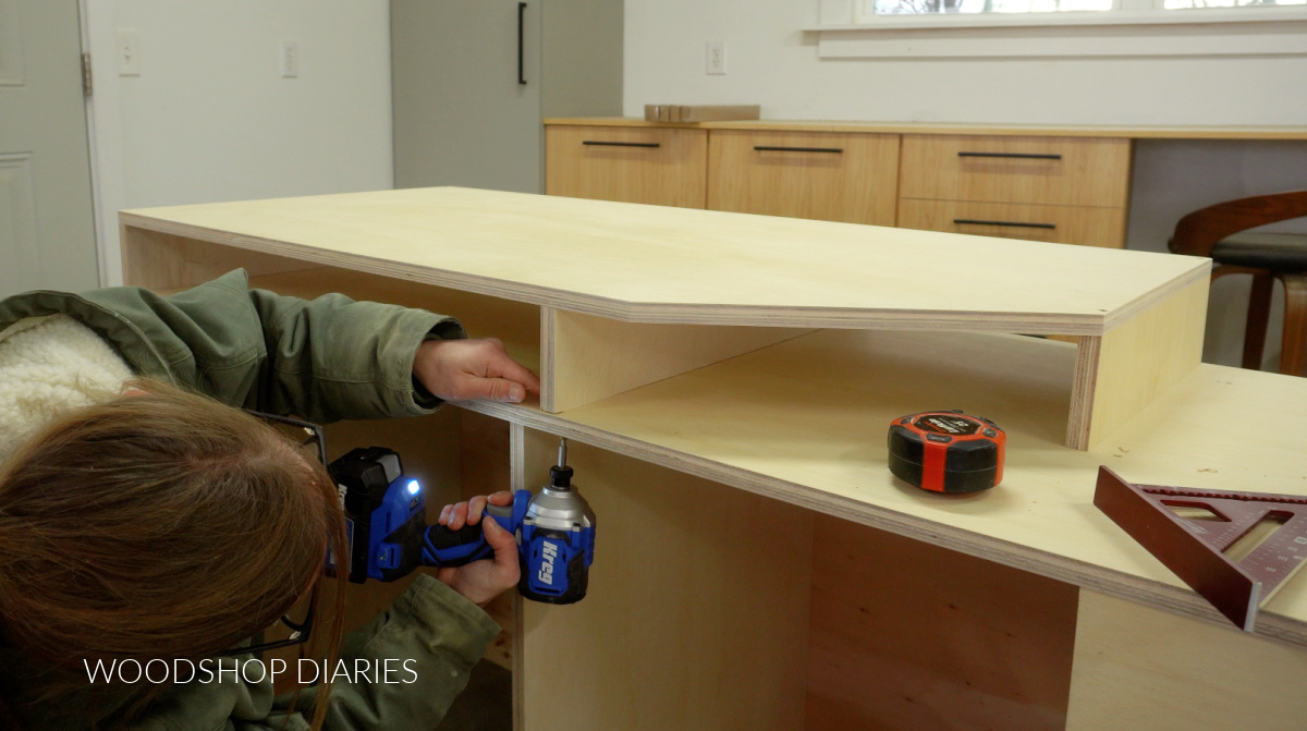 Shara Woodshop Diaries securing miter saw support risers onto miter saw stand