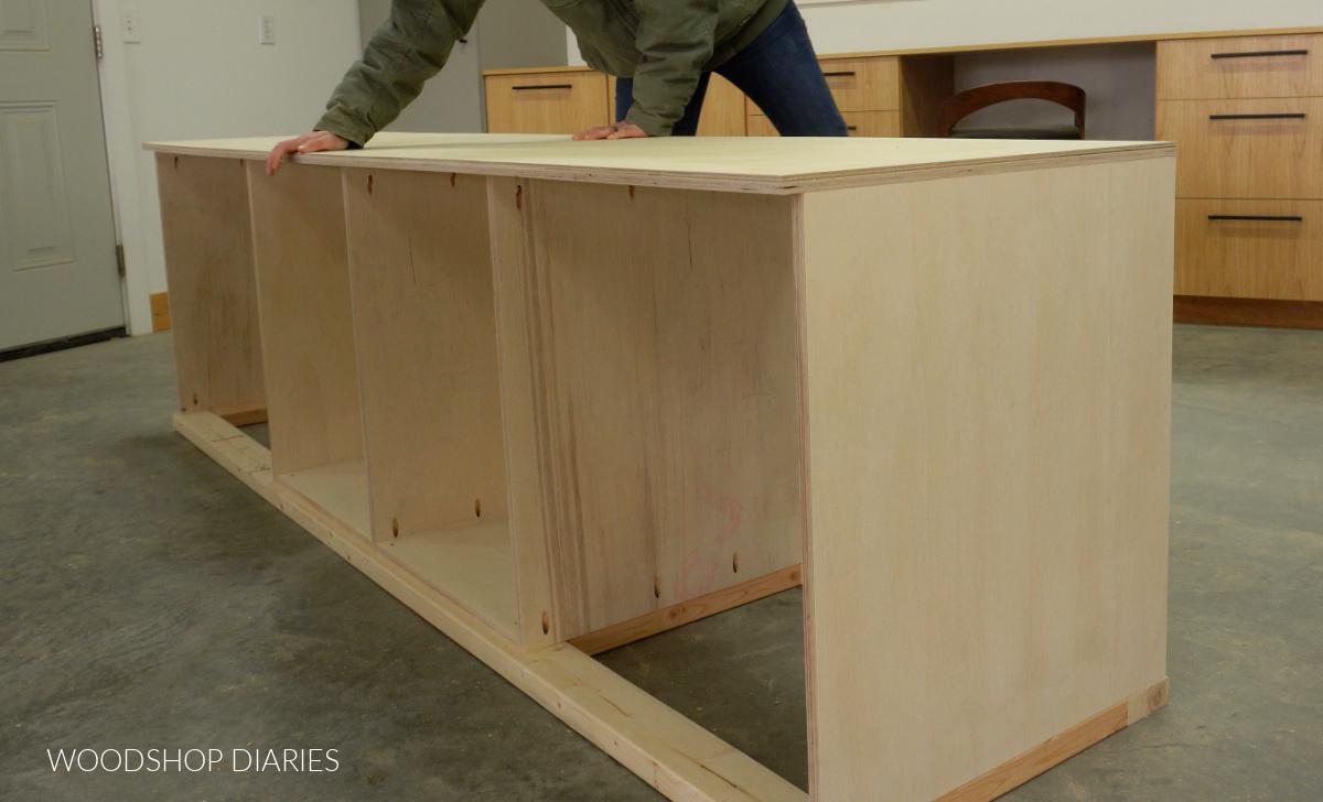 Shara Woodshop Diaries placing plywood top onto miter saw station
