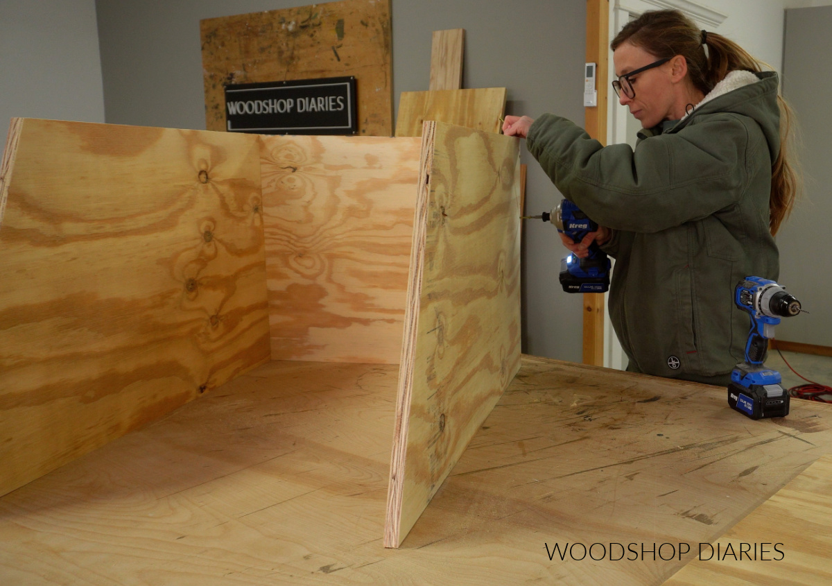 Shara Woodshop Diaries assembling free little pantry box on workbench with screws