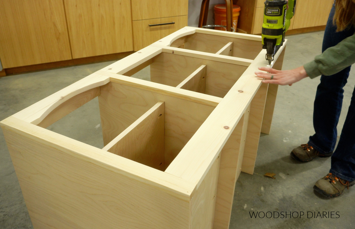 Shara Woodshop Diaries brad nailing face frame onto front of tv stand cabinet body