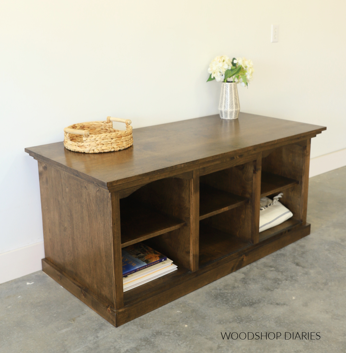 Finished DIY TV stand console viewed from the front corner with modern trim around top and bottom and stained dark brown