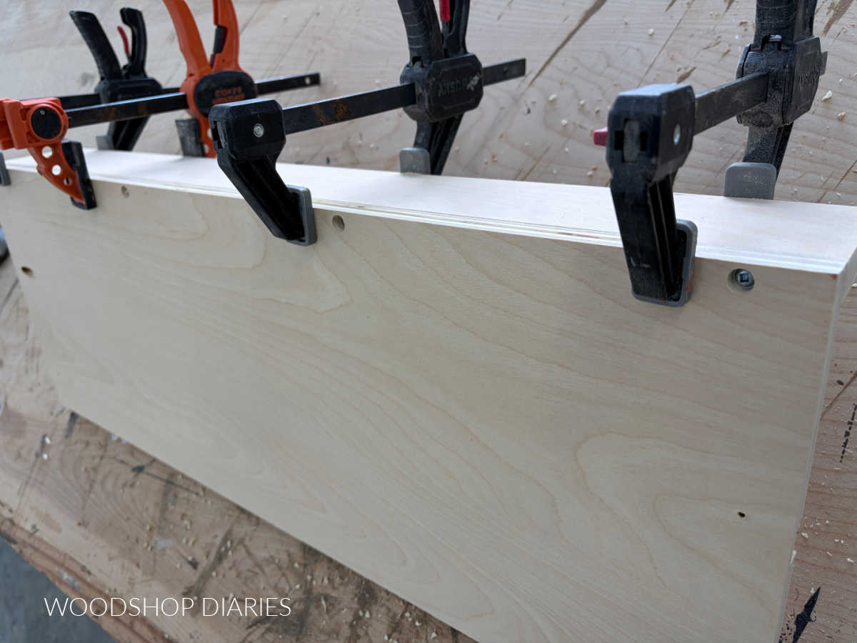 Back rail of small parts jig clamped to bottom piece with screws along edge