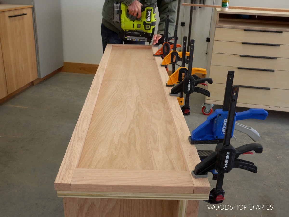Shara Woodshop Diaries brad nailing trim pieces onto sides of barrister bookcase