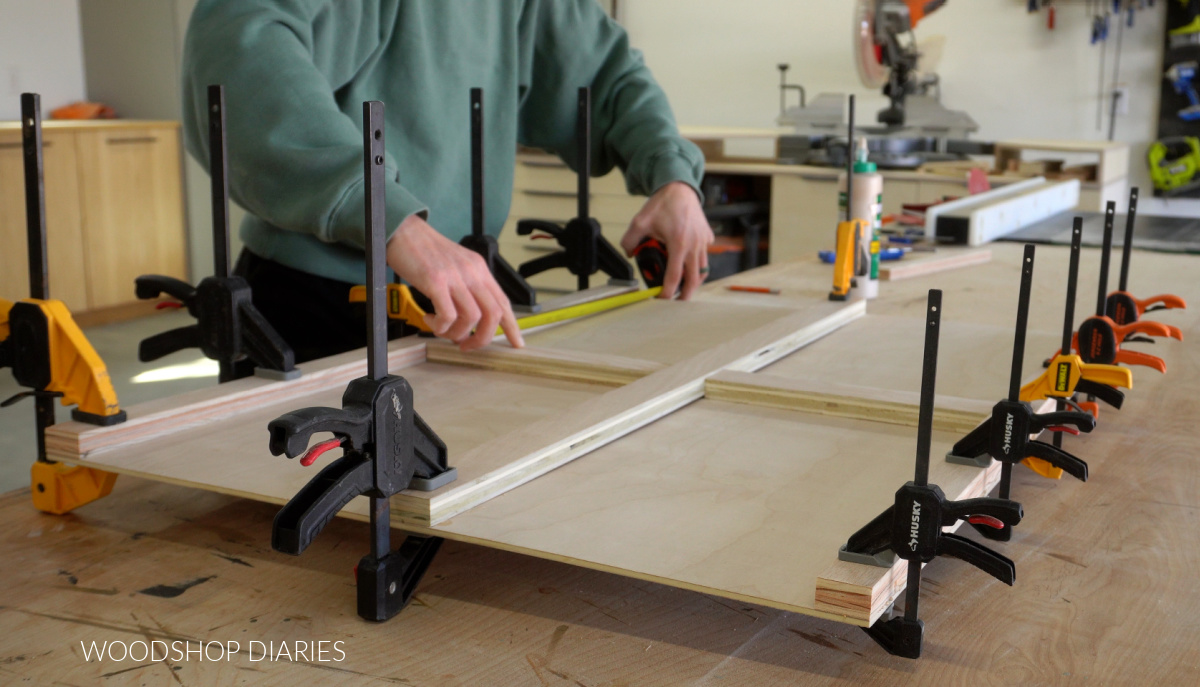 Shara Woodshop Diaries gluing and clamping puzzle board frame pieces to top panel