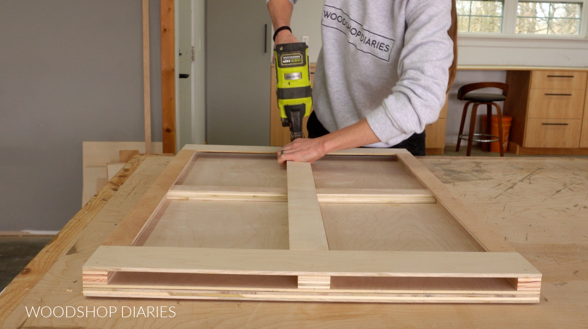 Shara Woodshop Diaries brad nailing ¼" plywood strips onto the bottom of puzzle board