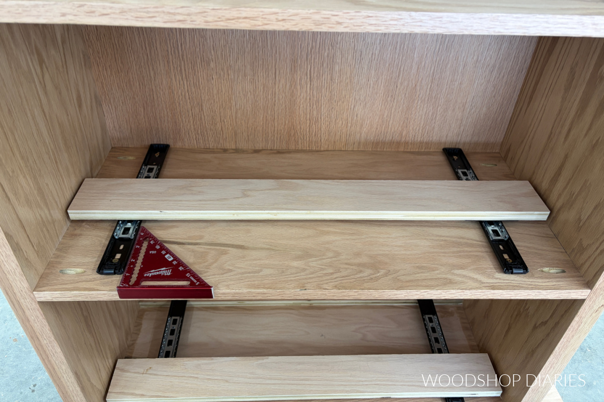 pocket door hardware slides mounted to underside of bookcase shelves with a speed square