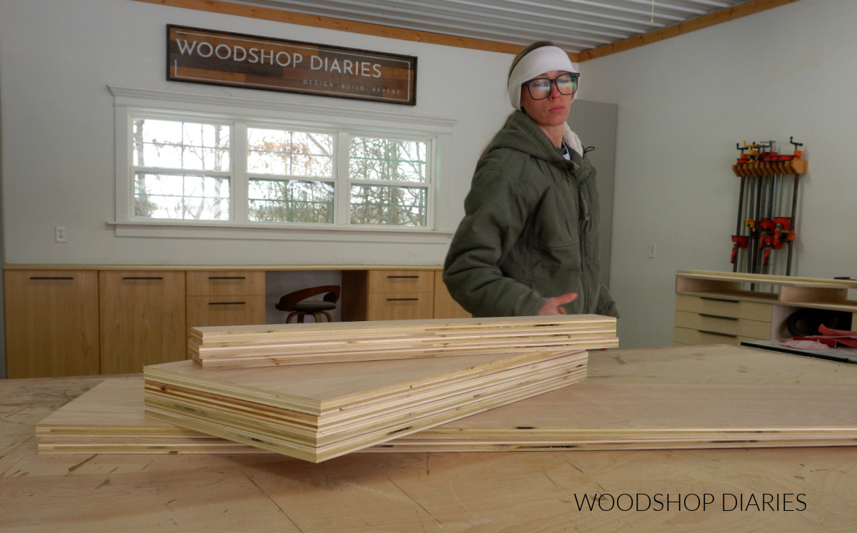 Shara Woodshop Diaries placing cut plywood parts on workbench to prepare for building