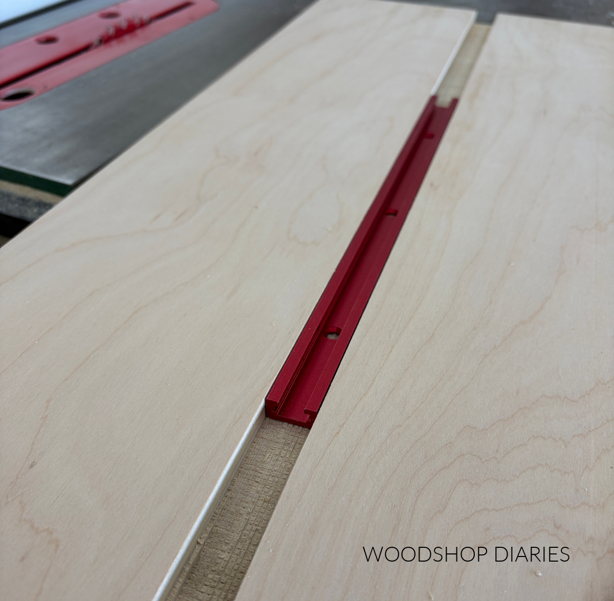 T track placed in slot cut in ¾" plywood panel for small parts miter saw jig