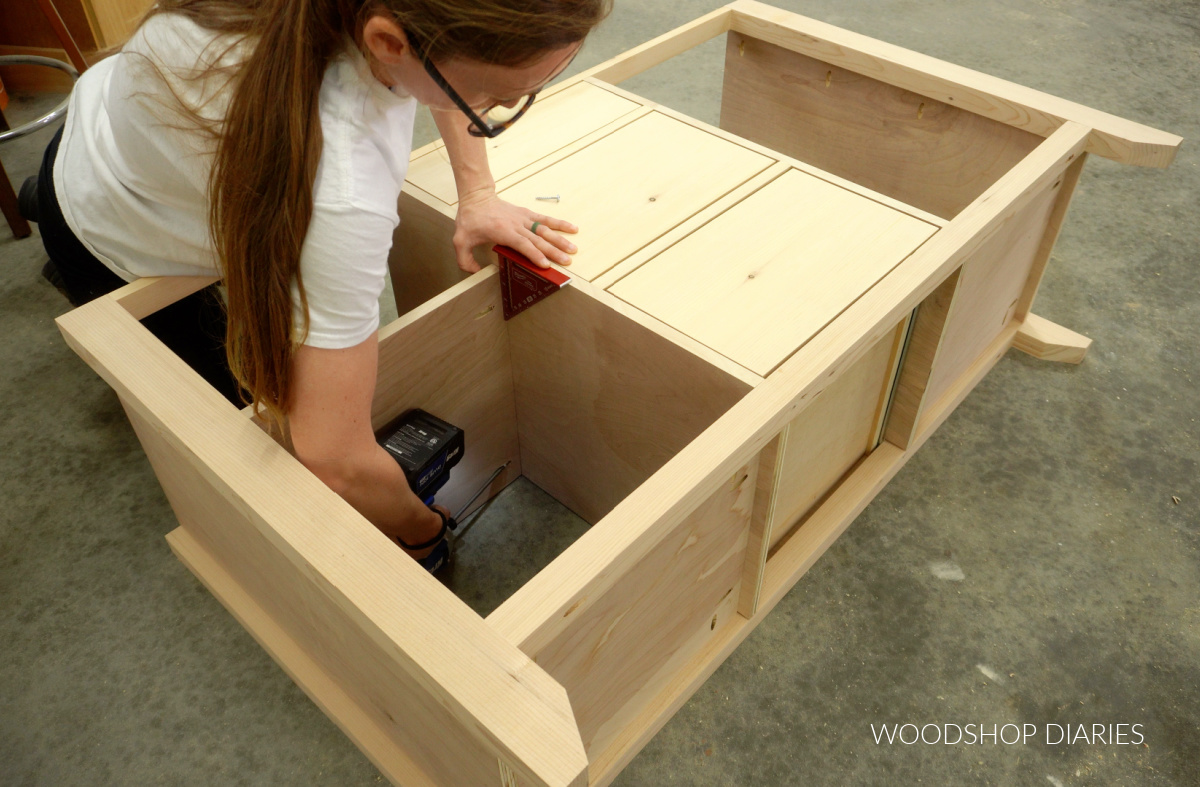 Shara Woodshop Diaries securing shelves into open sections of buffet table with pocket hole screws