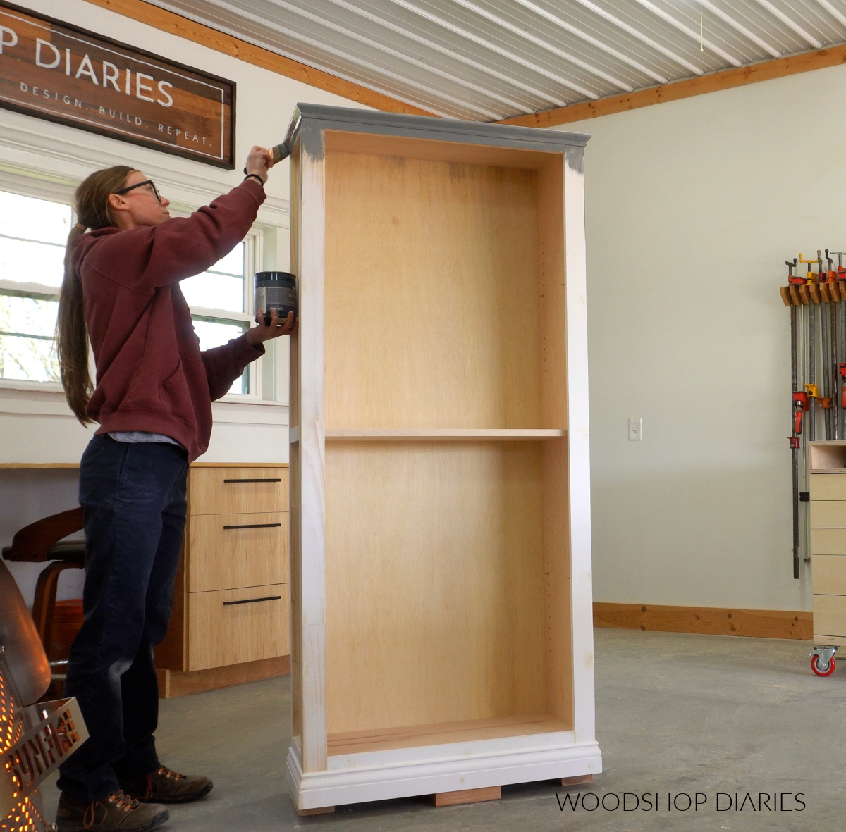 Shara Woodshop Diaries painting bookshelf blue in workshop