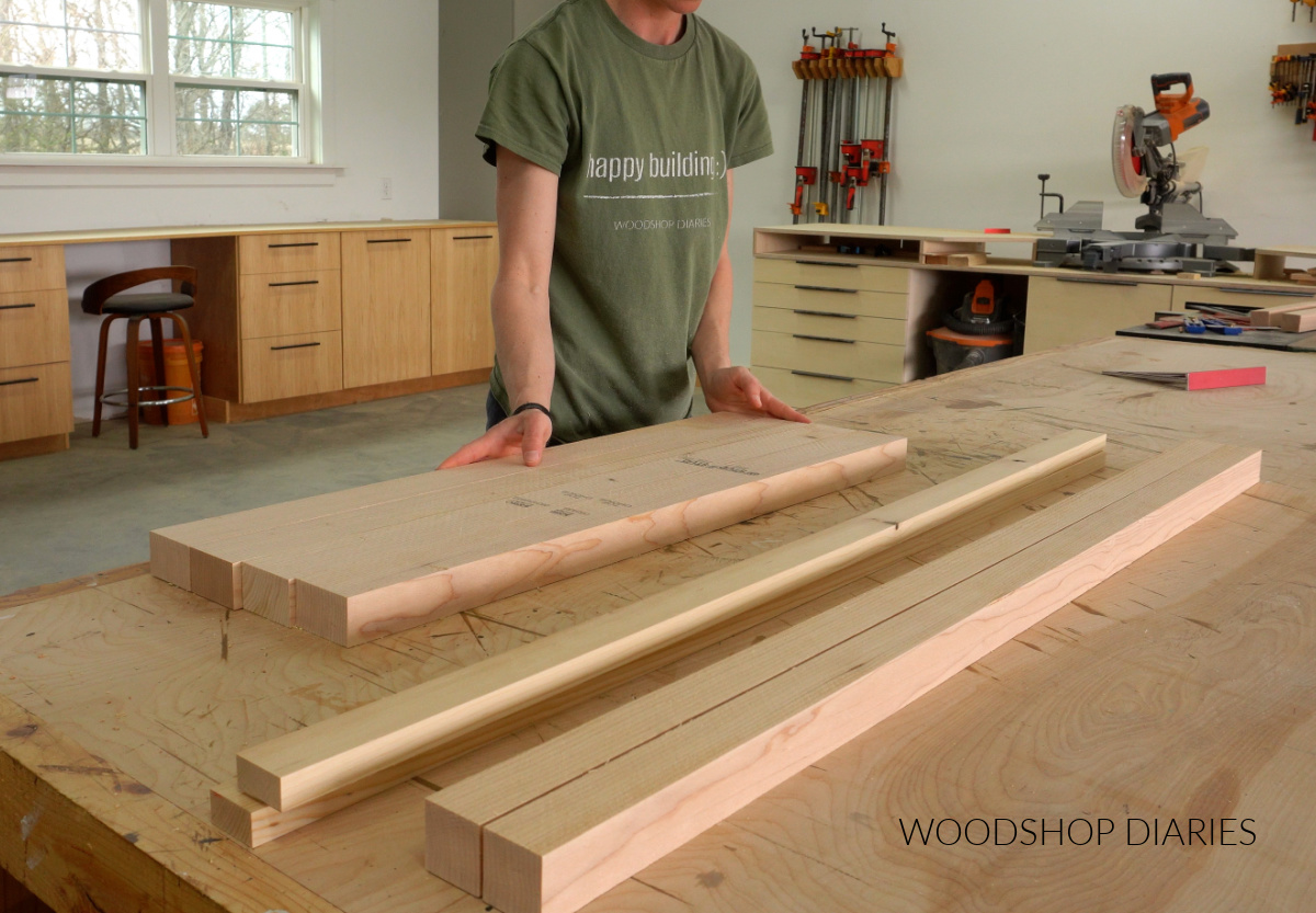 Shara Woodshop Diaries placing lumber on workbench to assemble buffet table frames