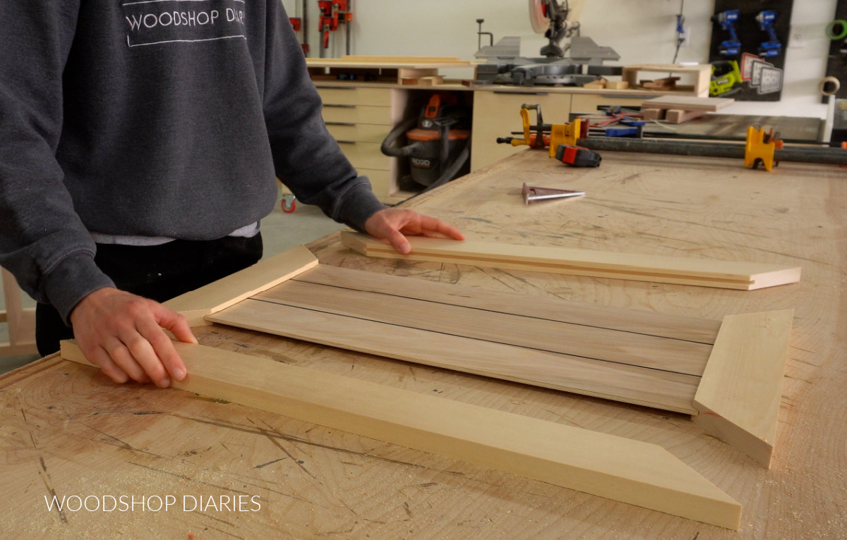 Shara Woodshop Diaries test fitting door frame and panel pieces together on workbench