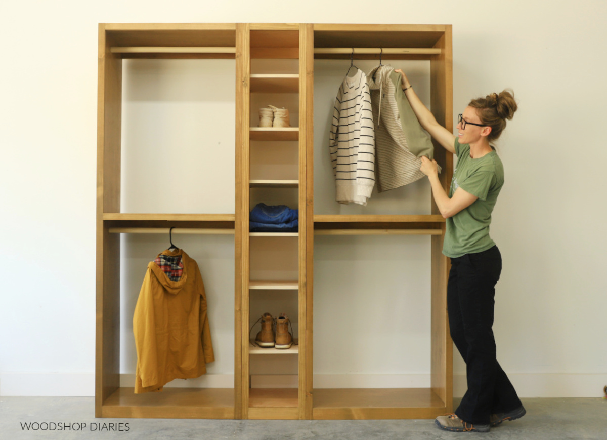 Shara Woodshop Diaries hanging shirt on DIy wooden closet tower cabinet with hanging rods