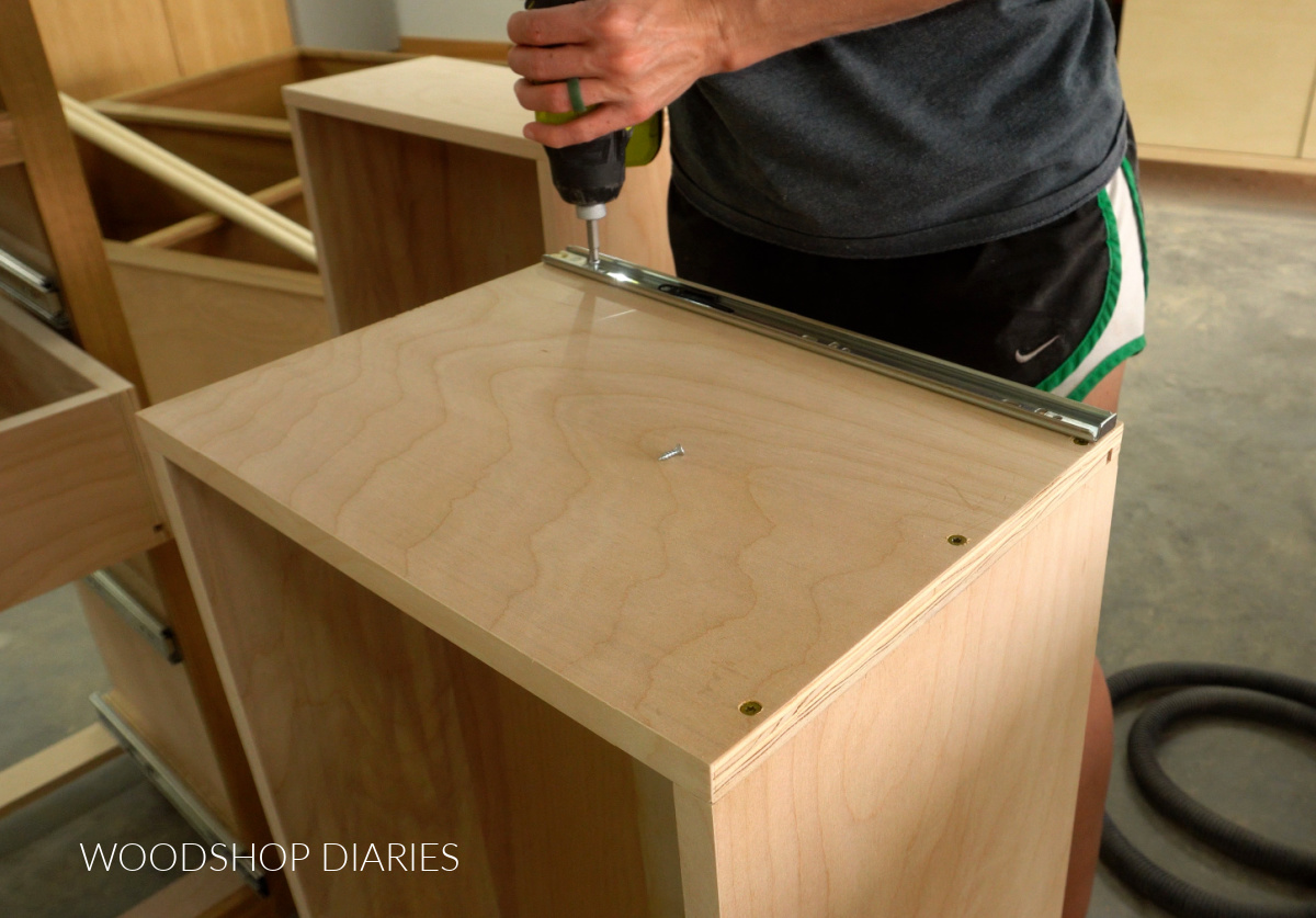 Close up Shara Woodshop Diaries installing drawer slides onto side of drawer box
