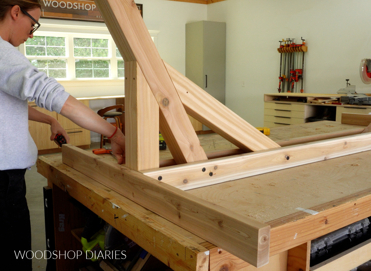 Shara Woodshop Diaries centering end brace onto hammock stand base on workbench