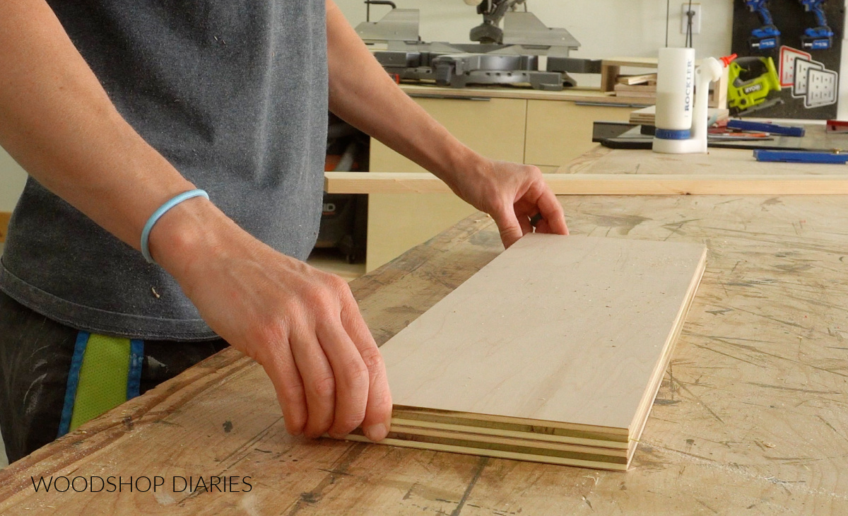 Shara Woodshop Diaries placing two plywood panels on workbench for floating shelf