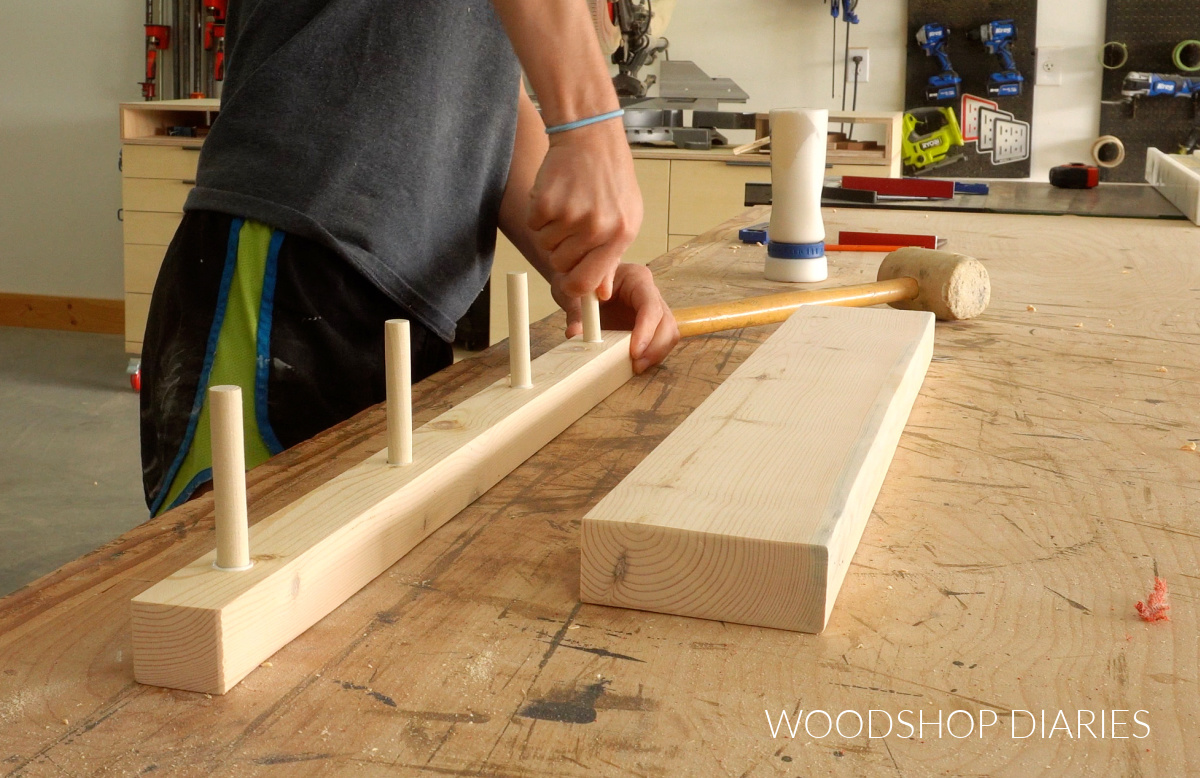 Shara Woodshop Diaries installing dowels in floating shelf board on workbench