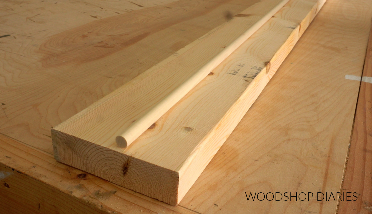 pine 2x6 board with ½" dowel rod sitting on top on workbench