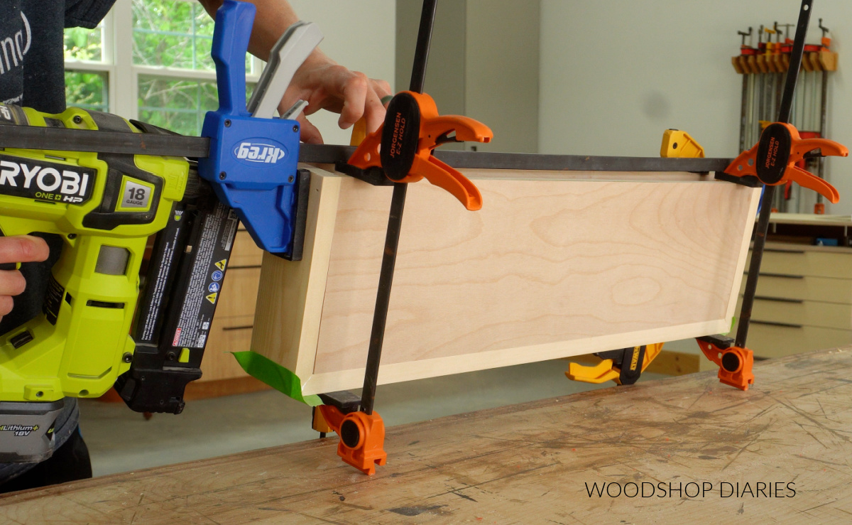 Shara Woodshop Diaries brad nailing shelf box together on workbench