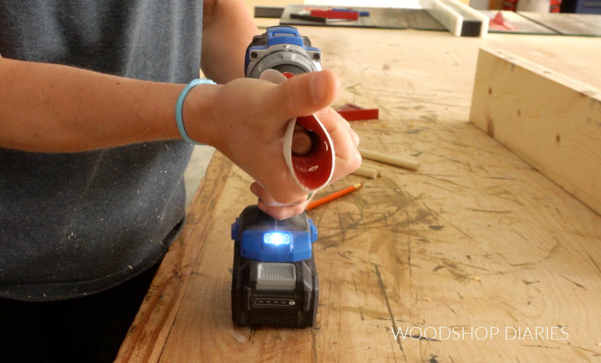 Using the drill to sand dowel rods down to size