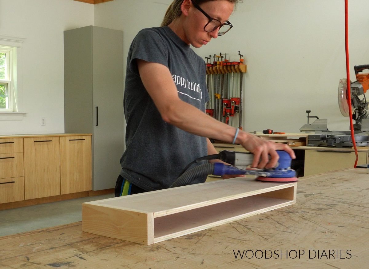 Shara Woodshop Diaries sanding hollow floating shelf box on workbench