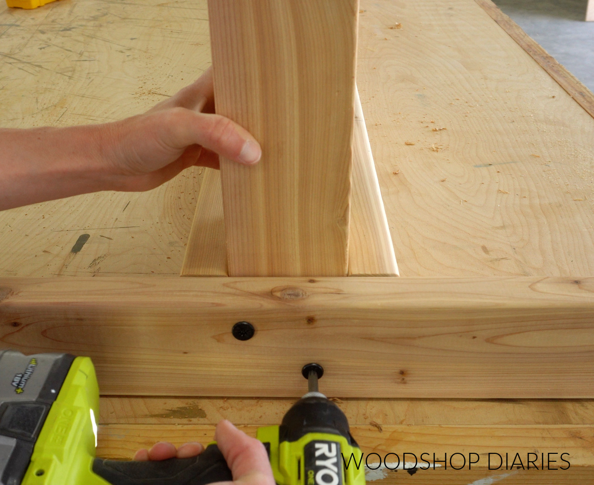 Close up of Shara Woodshop Diaries driving screws to secure end brace of hammock stand