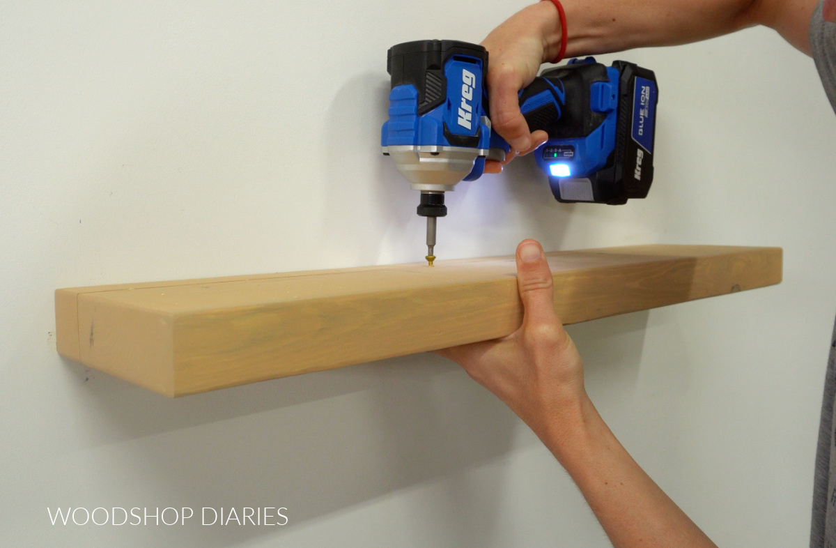 Securing floating shelf board to dowels using screws from top