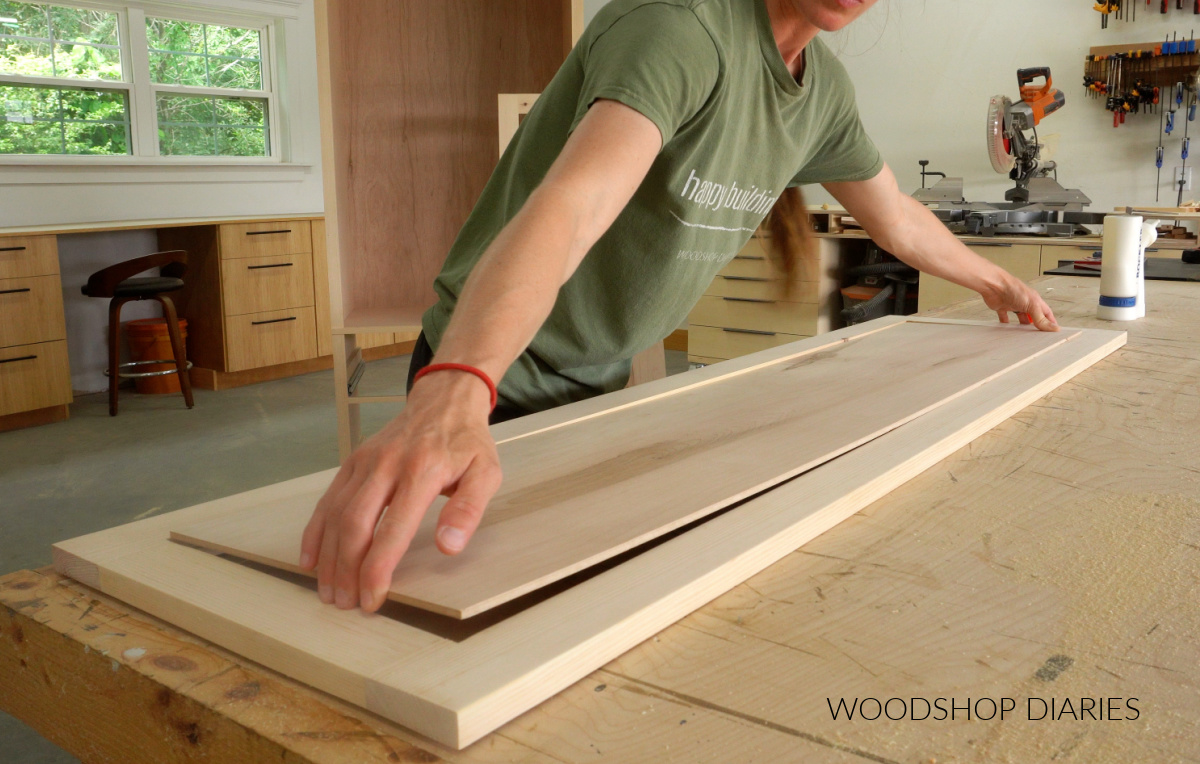 Shara Woodshop Diaries installing door panel into door frame on workbench