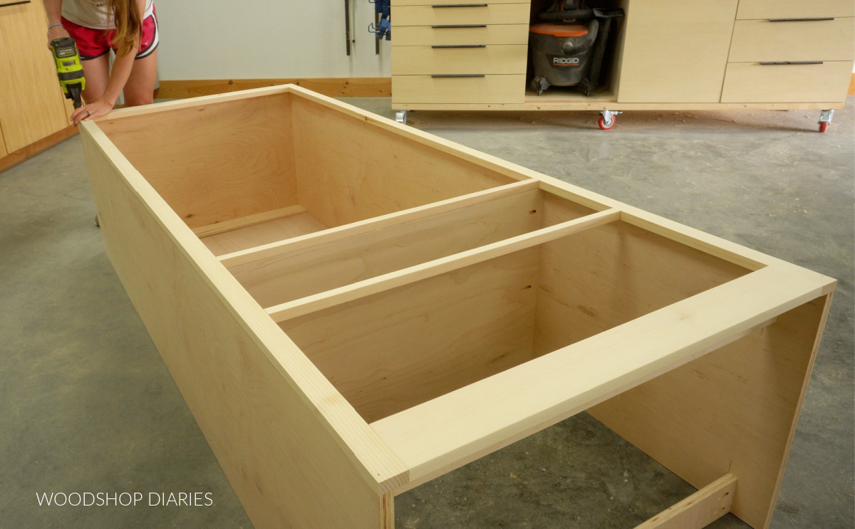 Shara Woodshop Diaries brad nailing face frame onto front of armoire cabinet box