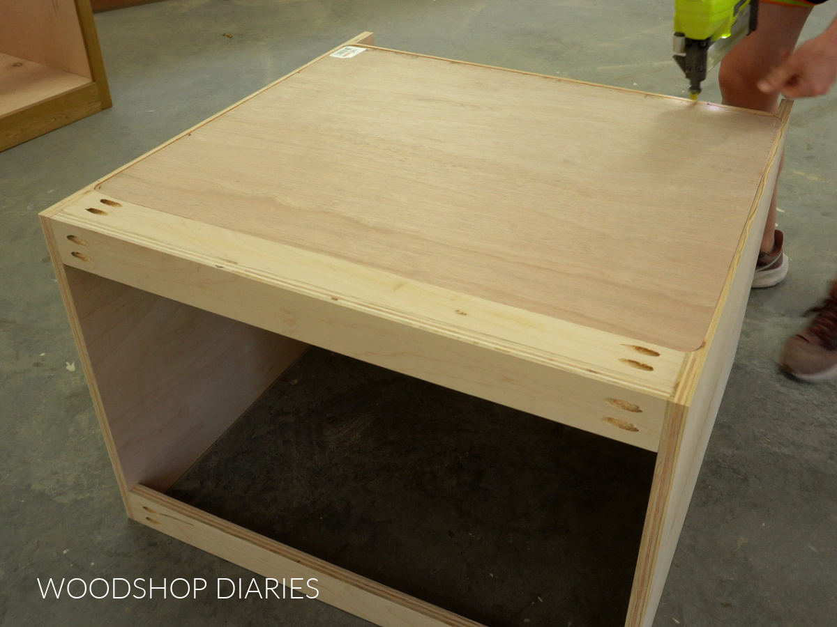 Shara Woodshop Diaries stapling back panel onto back of cabinet box