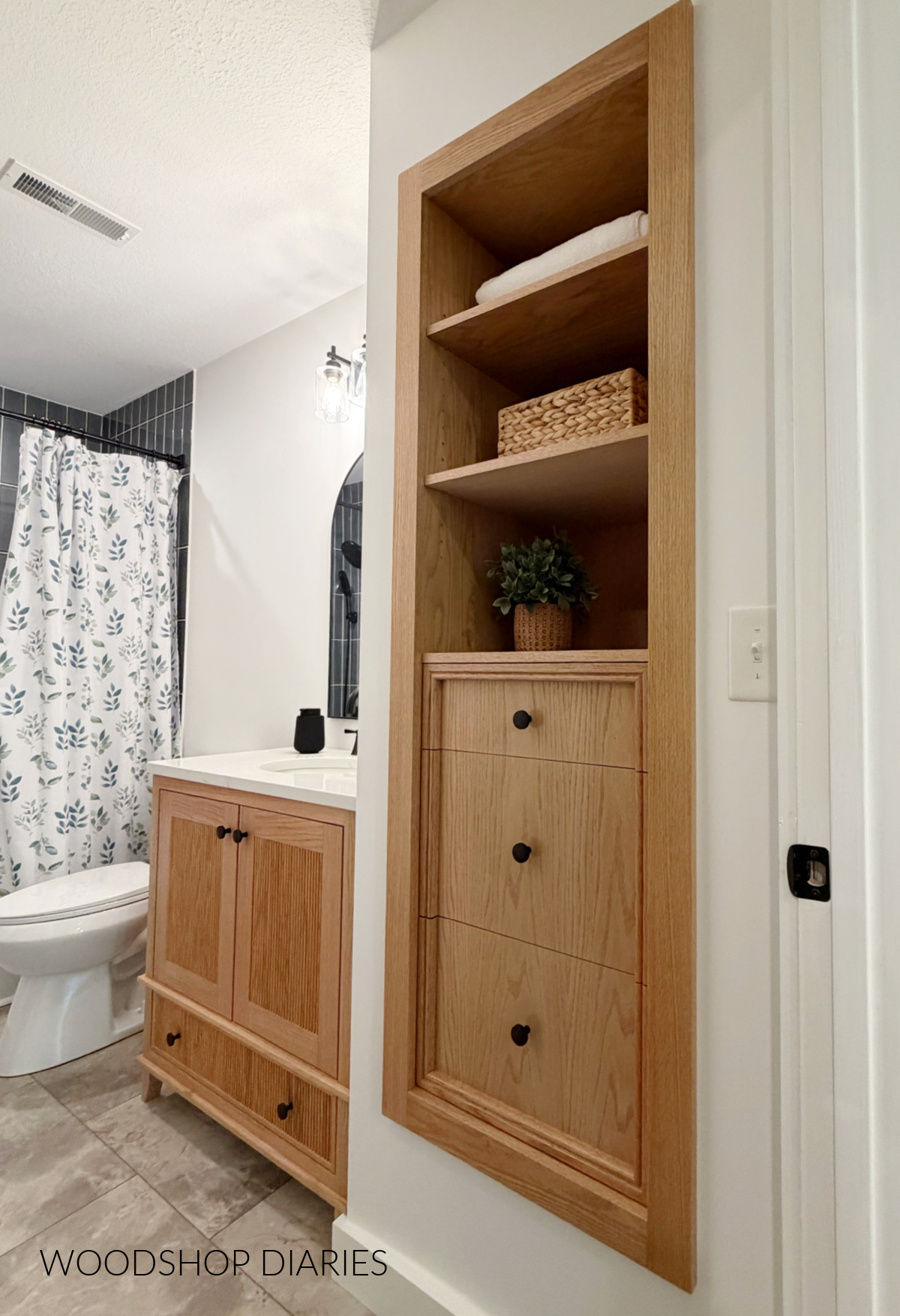 Completed bathroom remodel with built in red oak cabinet in place of regular closet door