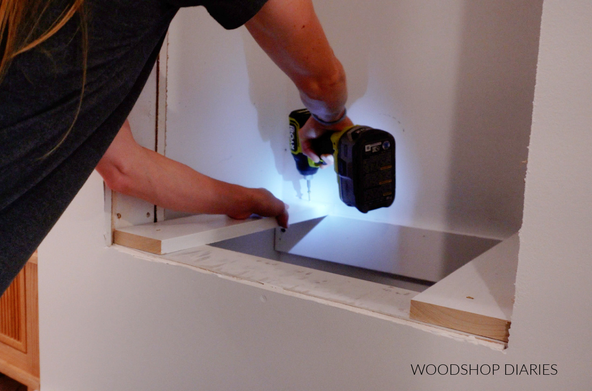 Shara Woodshop Diaries securing bottom supports into cabinet opening to add built in