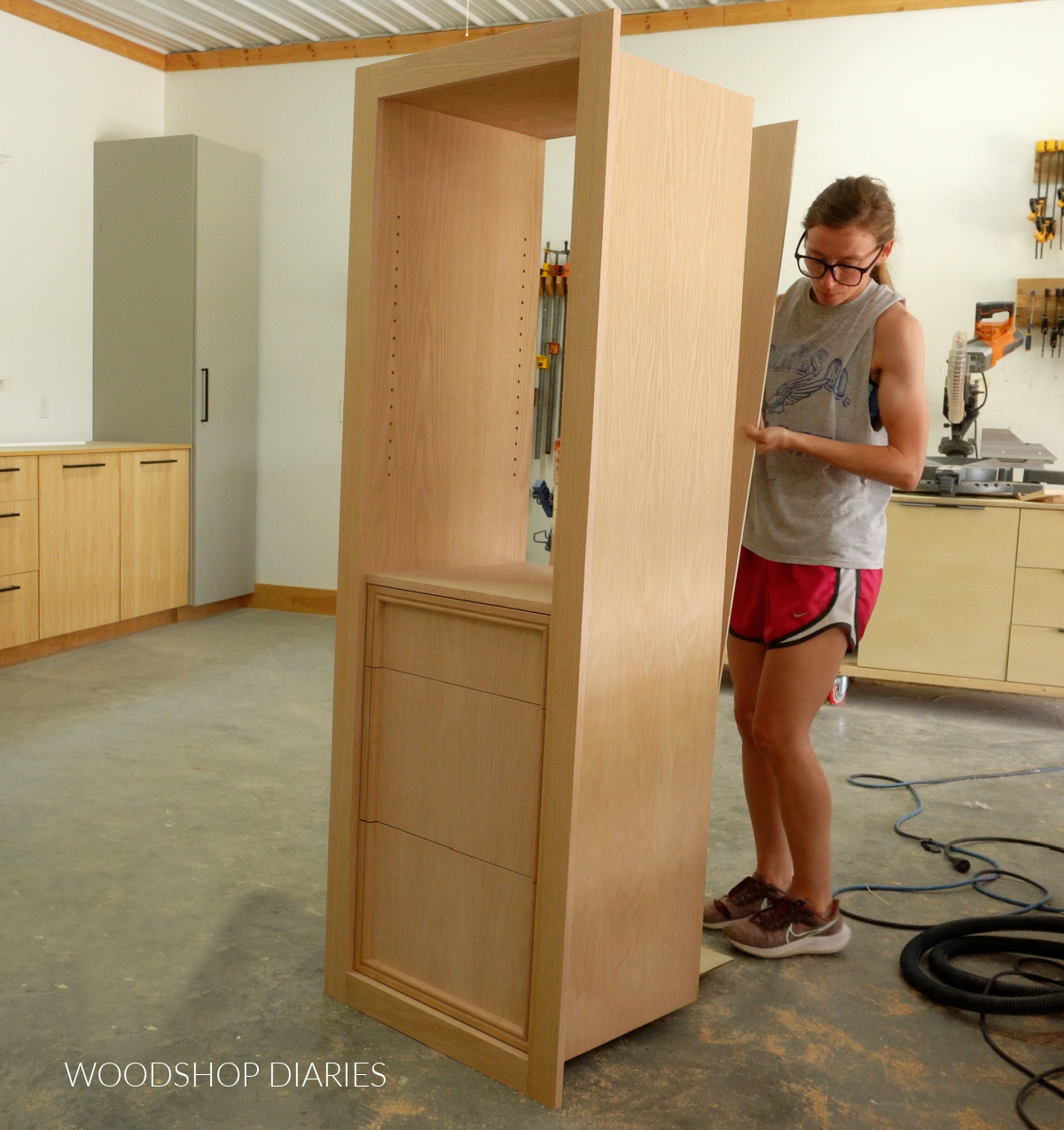 Shara Woodshop Diaries placing ¼" plywood panel onto back of built in cabinet