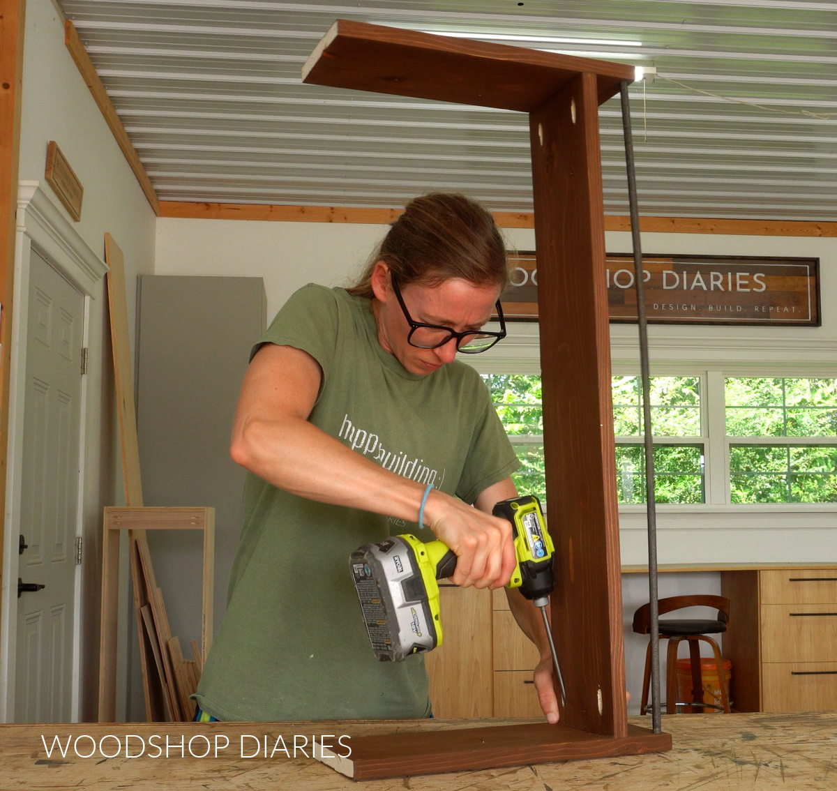 Shara Woodshop Diaries screwing over the stove shelf assembly together on workbench
