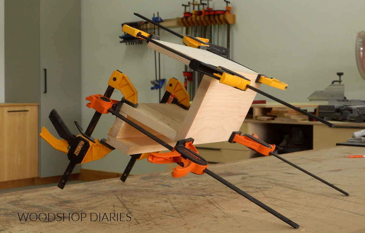 Sofa arm tray clamped together on workbench
