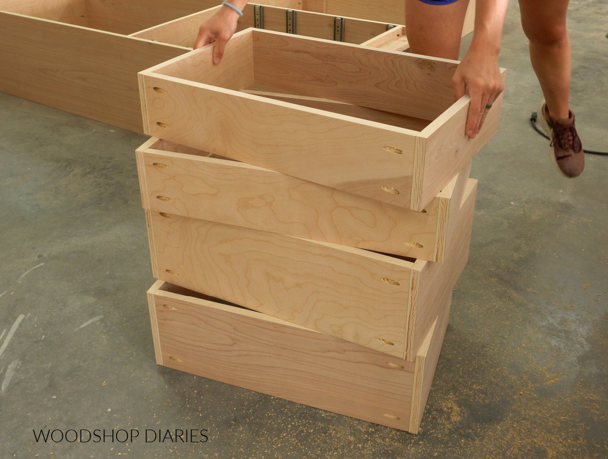 Stack of plywood drawer boxes on workshop floor
